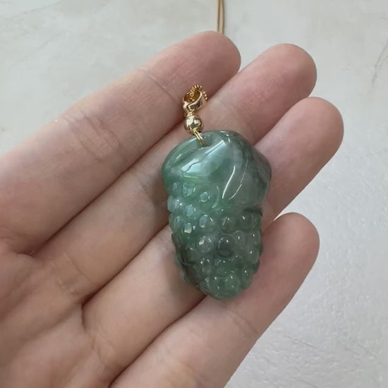 Video of a hand-carved natural jade grape cluster pendant with rounded green stone detail and dimensional artisan style