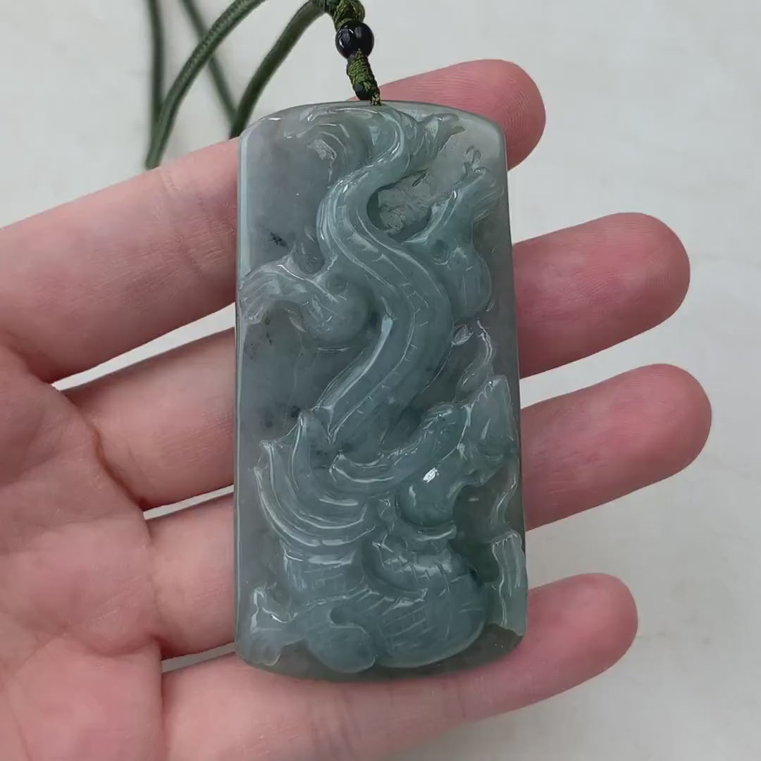 Video of a hand-carved green jadeite Dragon and Phoenix pendant with intricate, semi-translucent details and natural glow