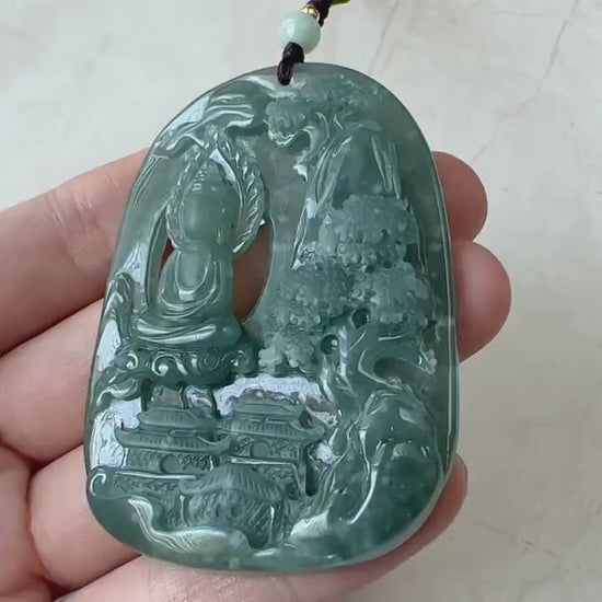 Video of a polished deep green carved stone pendant with a faceless Buddha and tranquil mountain relief scene