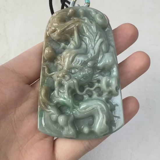 Video of a hand-carved natural jadeite dragon pendant in rich green and golden-yellow hues with detailed scales and claws