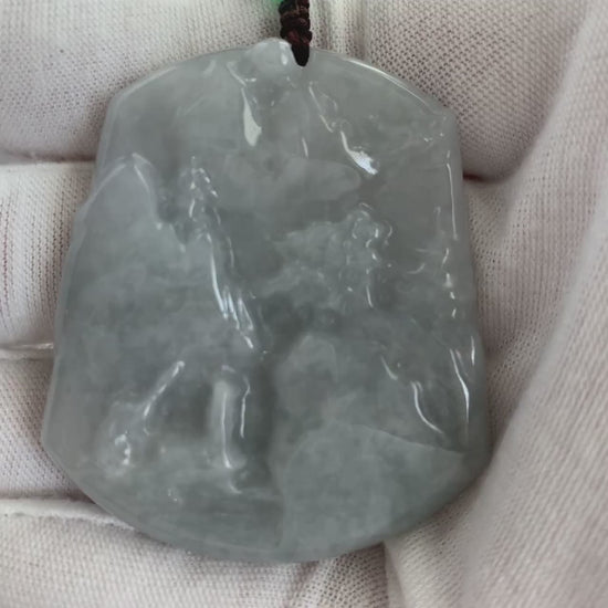 Video of a hand-carved jade pendant in green with an abstract moonlit mountain and forest landscape design