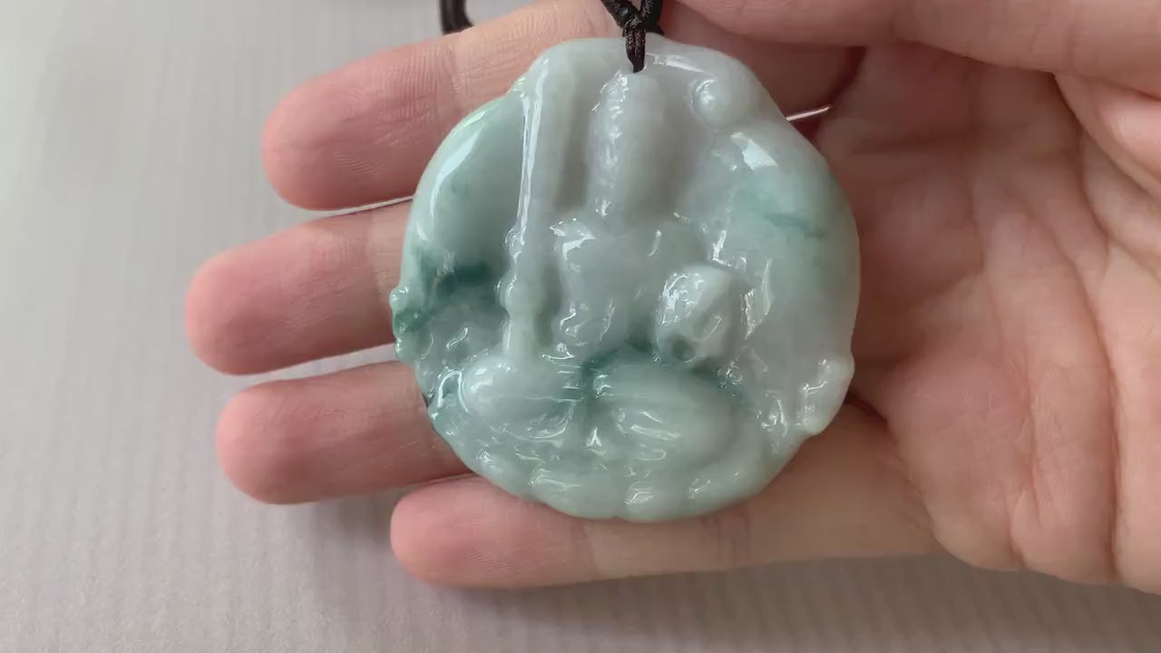 Video of a hand-carved natural jadeite jade pendant featuring Acala Buddha in green with intricate details