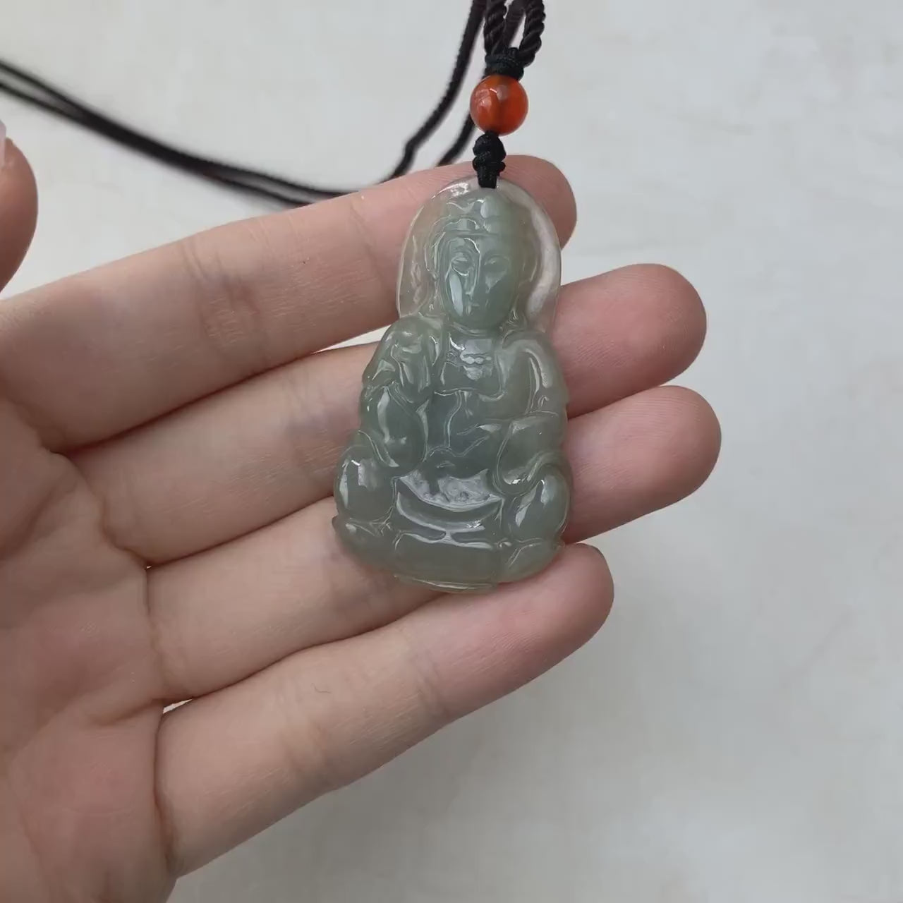 Video of a hand-carved natural jadeite jade Guan Yin pendant in elegant green with detailed traditional carving