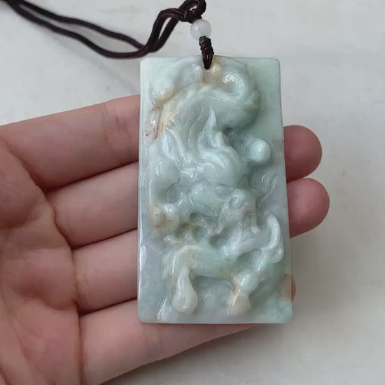 Video of a hand-carved natural jadeite jade dragon pendant in green with rustic, organic texture and intricate details