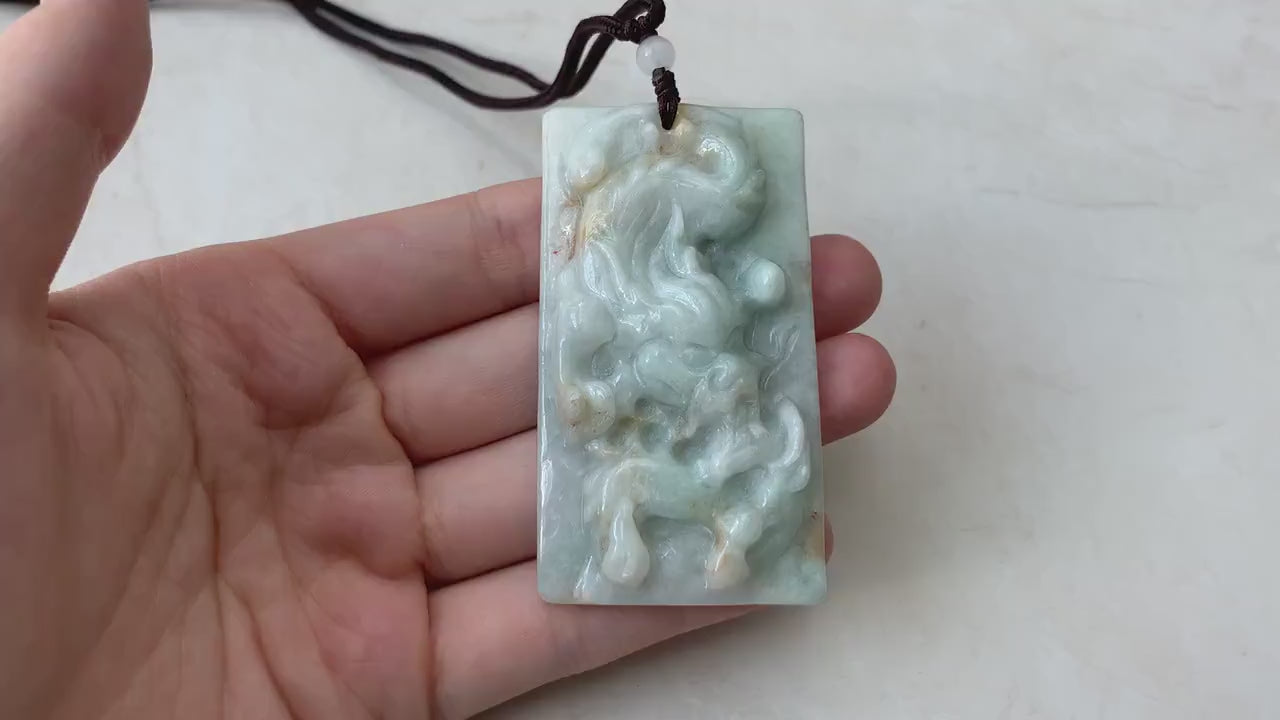 Video of a hand-carved natural jadeite jade dragon pendant in green with rustic, organic texture and intricate details