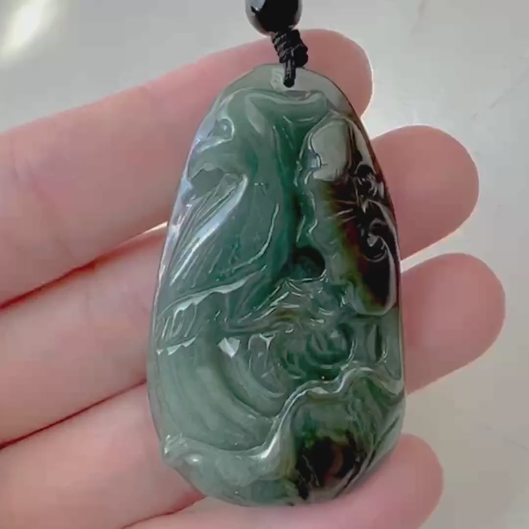 Video of a hand-carved pendant with a graceful bird and delicate floral motifs, detailed and elegant in style