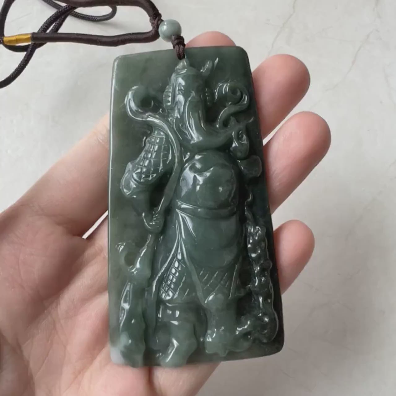 Video of a hand-carved green jadeite jade Guan Gong pendant with detailed, traditional craftsmanship