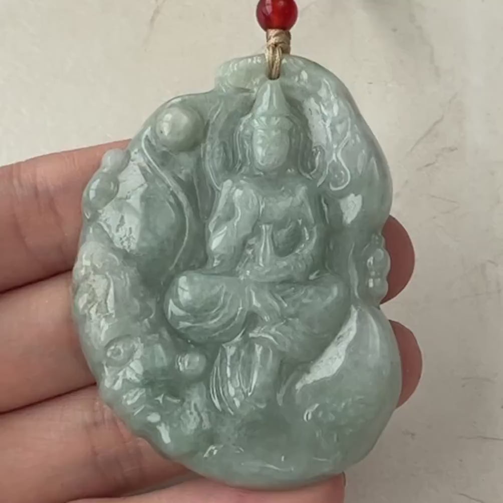 Video of a hand-carved green jade Guan Yin pendant in a serene meditative style with intricate detail