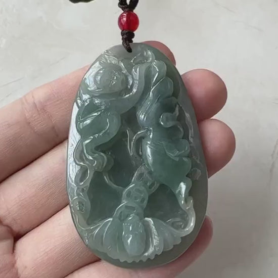 Video of a hand-carved vivid green jade necklace with monkey, bat and floral motifs and an abstract carved reverse