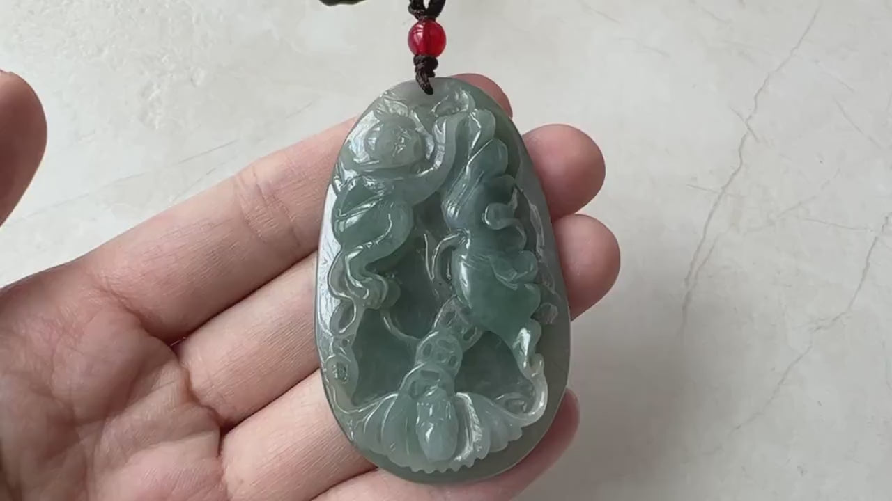 Video of a hand-carved vivid green jade necklace with monkey, bat and floral motifs and an abstract carved reverse