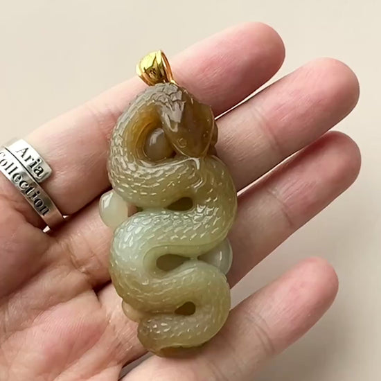 Video of hand-carved jade snake pendant in honey and yellow tones with 18K gold bail and leaf motif