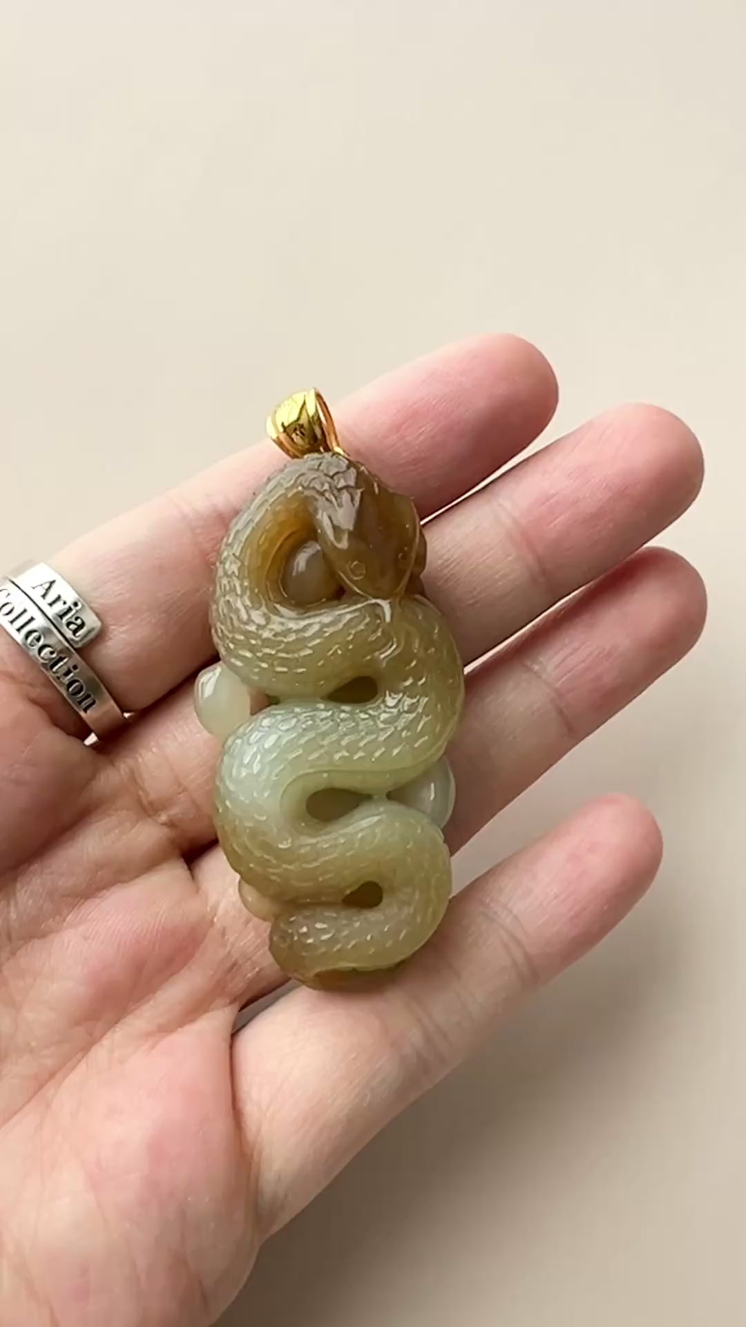 Video of hand-carved jade snake pendant in honey and yellow tones with 18K gold bail and leaf motif