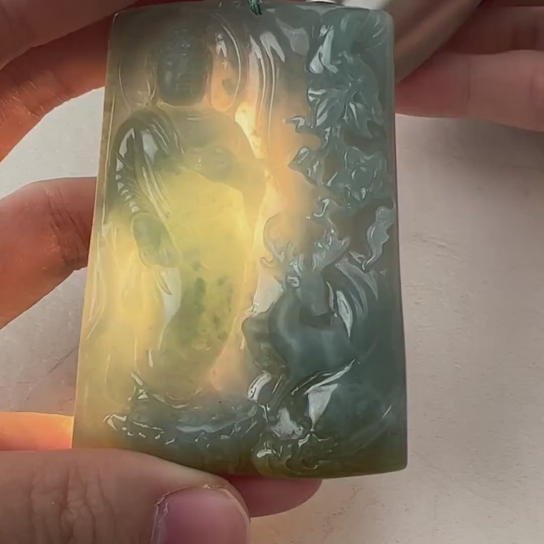 Video of hand-carved green-blue jade Buddha pendant with yellow splashes and serene forest deer scene