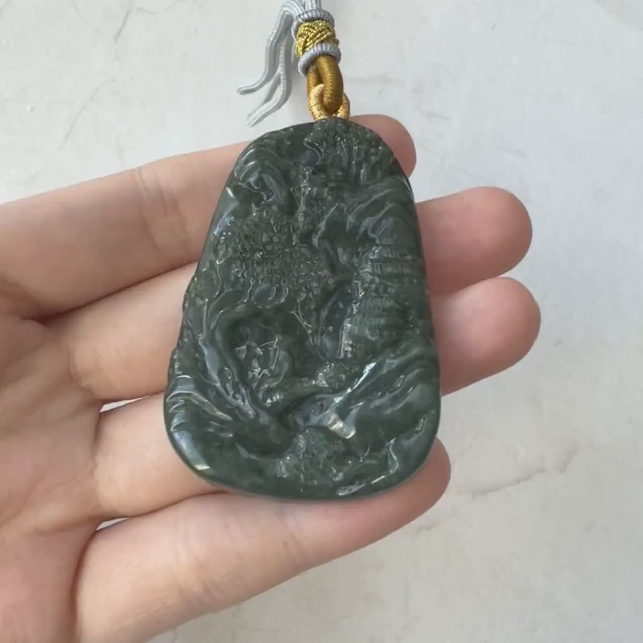 Video of a one-of-a-kind dark green jadeite pendant with hand-carved mountain, river, and tree landscape design
