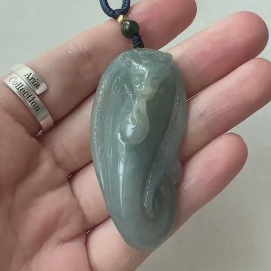 Video of a hand-carved green jadeite snake pendant with detailed scales and a soft translucent glow
