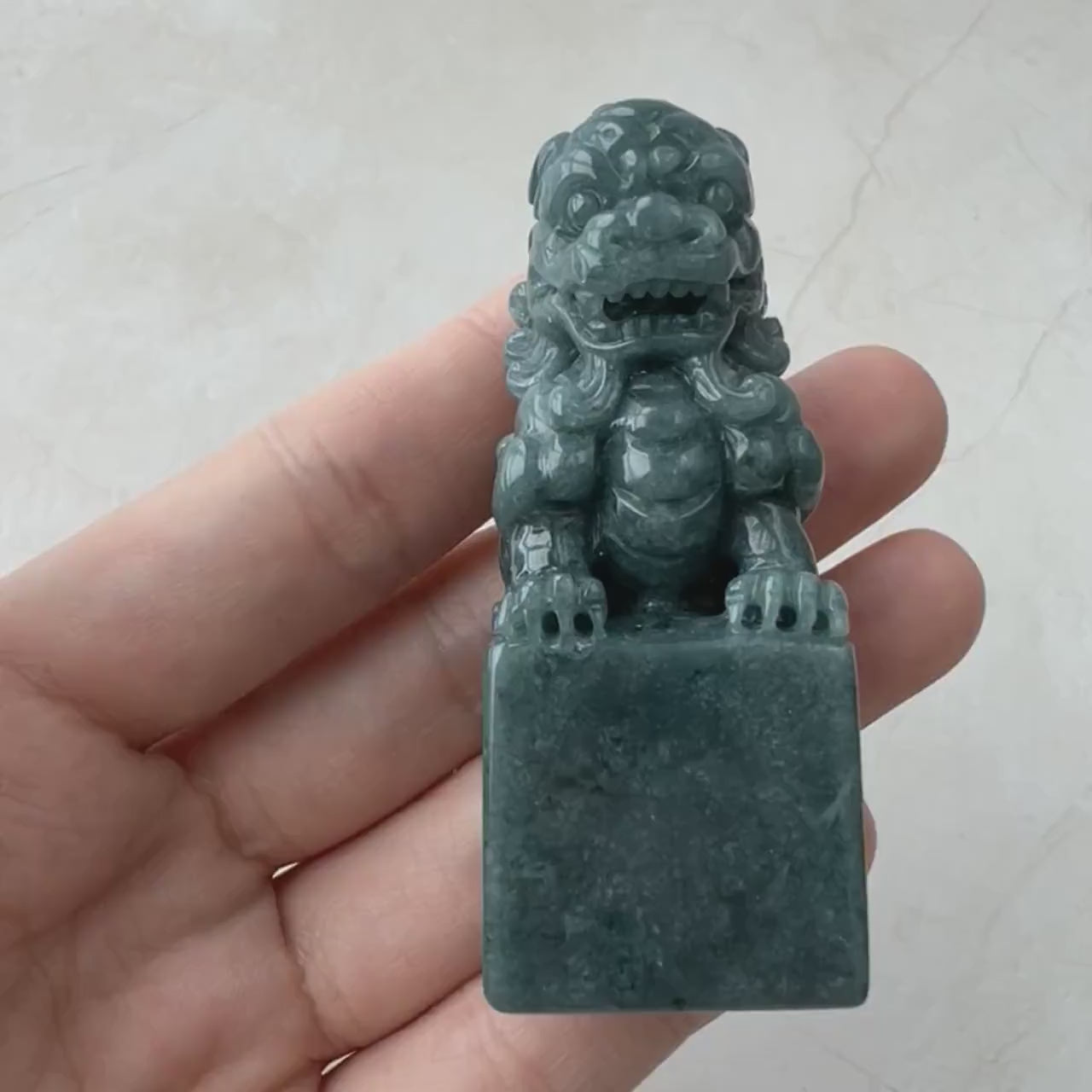 Video of a hand-carved green jadeite Imperial Guardian Lion with detailed carving and a solid display base