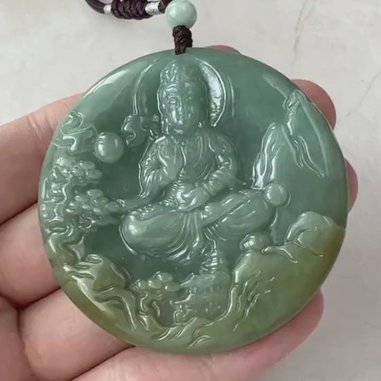 Video of a hand-carved jade pendant in serene green depicting Guan Yin with a tranquil mountain landscape