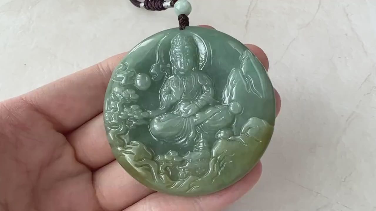 Video of a hand-carved jade pendant in serene green depicting Guan Yin with a tranquil mountain landscape