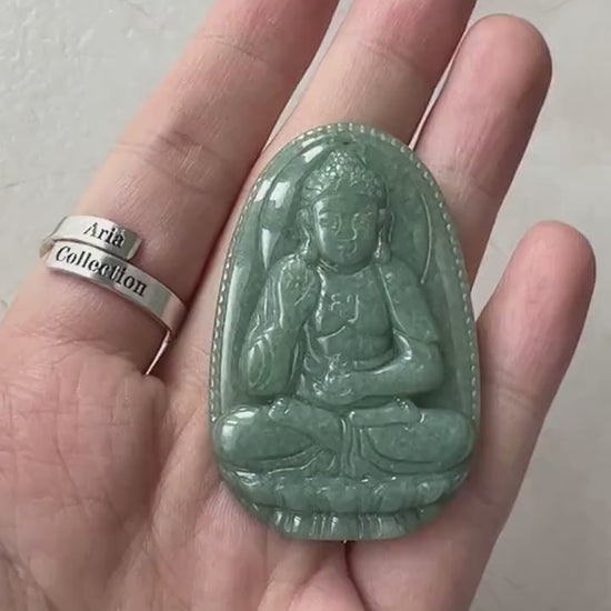 Video of a carved green jade Amitabha Buddha pendant with serene, meditative Buddhist-inspired detail