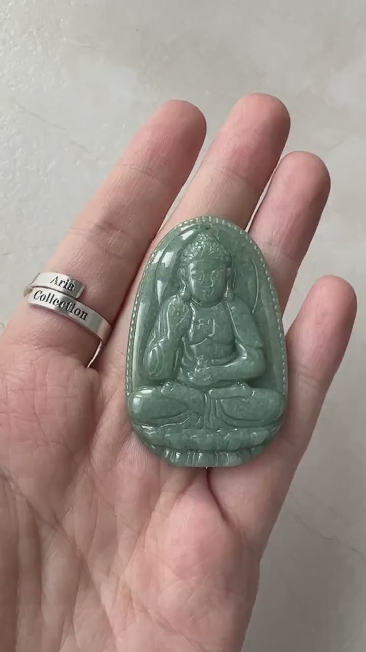 Video of a carved green jade Amitabha Buddha pendant with serene, meditative Buddhist-inspired detail