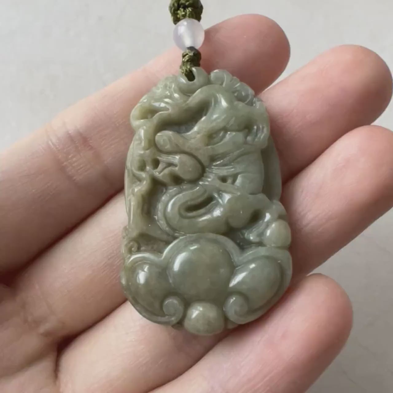 Video of natural green jadeite dragon pendant with Ruyi carving, hand-carved, detailed, and symbolic