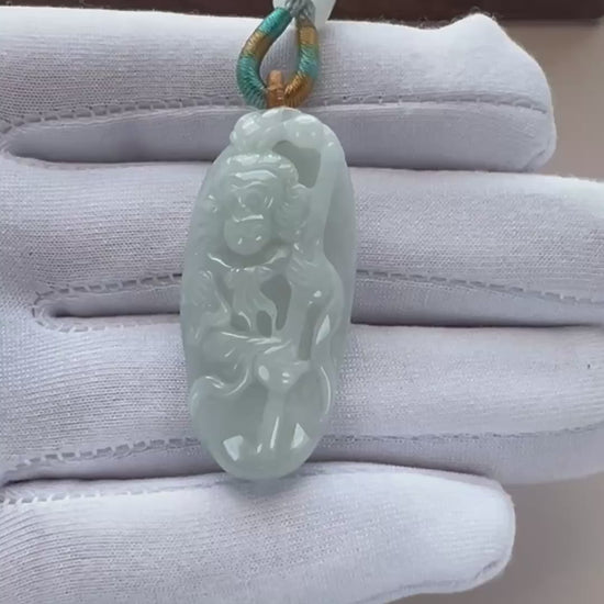 Video of pale light blue-green jade oval pendant with Monkey King relief carving, openwork details, and glossy finish