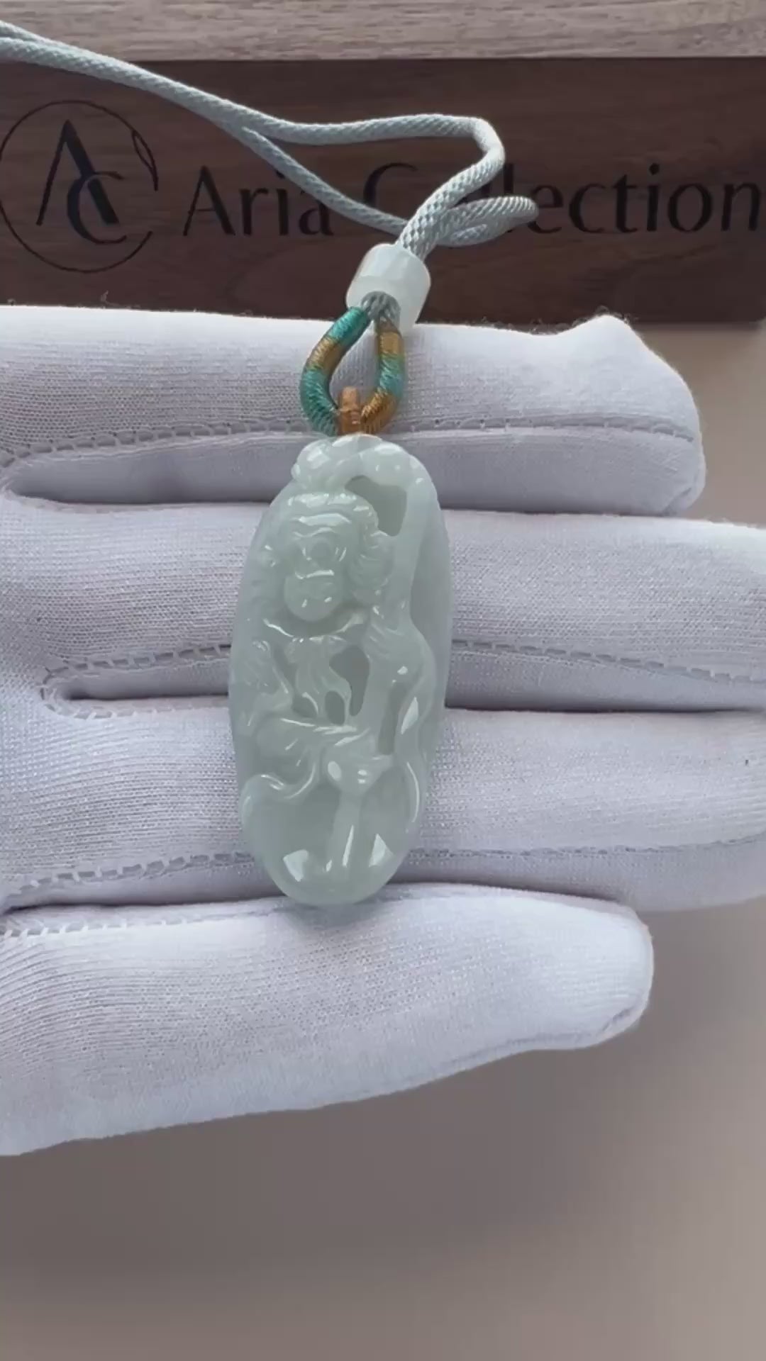 Video of pale light blue-green jade oval pendant with Monkey King relief carving, openwork details, and glossy finish