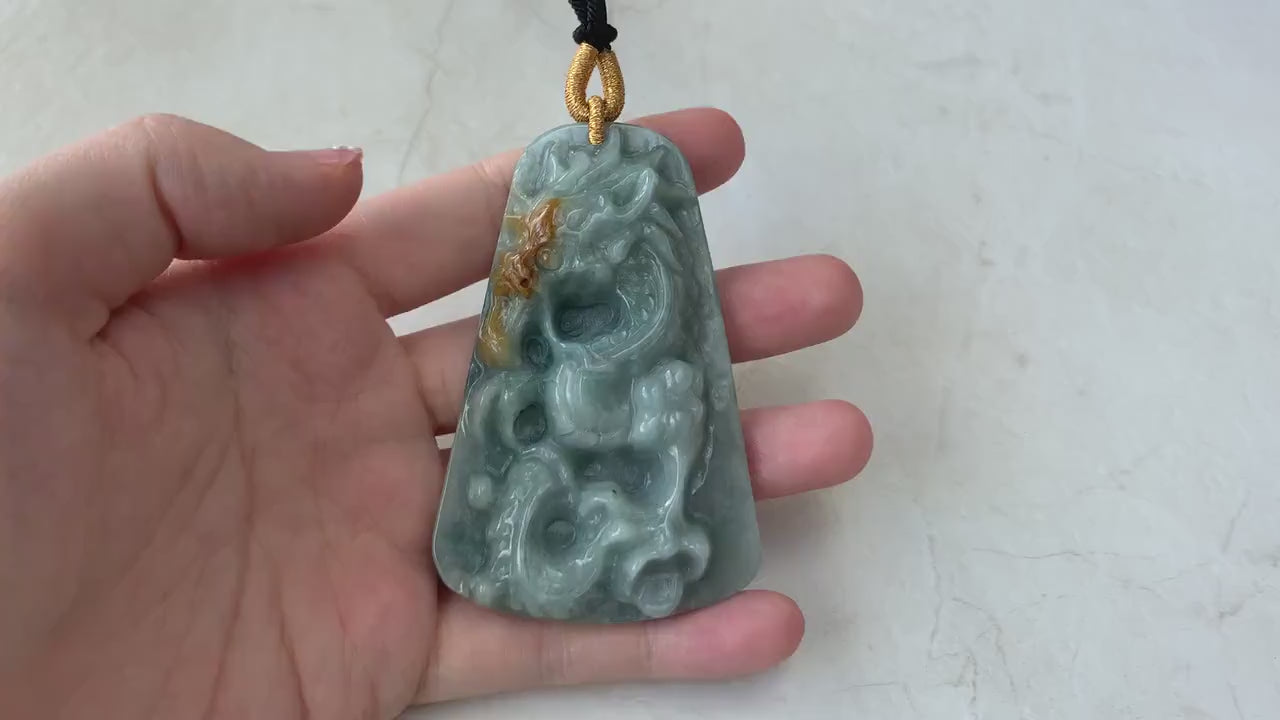 Video of natural green jadeite pendant with hand-carved dragon motif, detailed scales, claws, and tail, elegant and bold