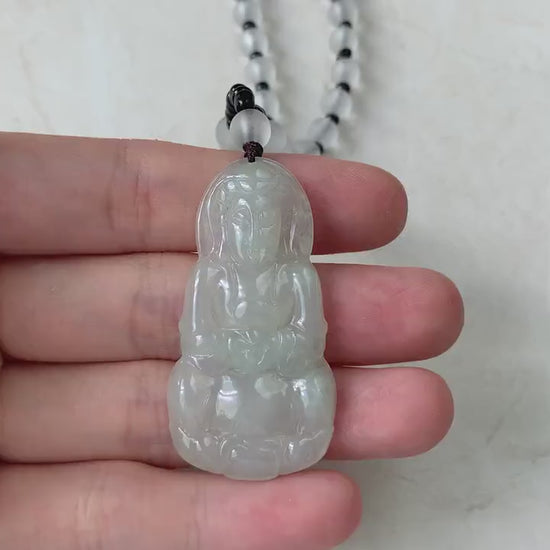 Video of a hand-carved natural jade Guan Yin pendant with intricate detailing and a beaded necklace, elegant green style