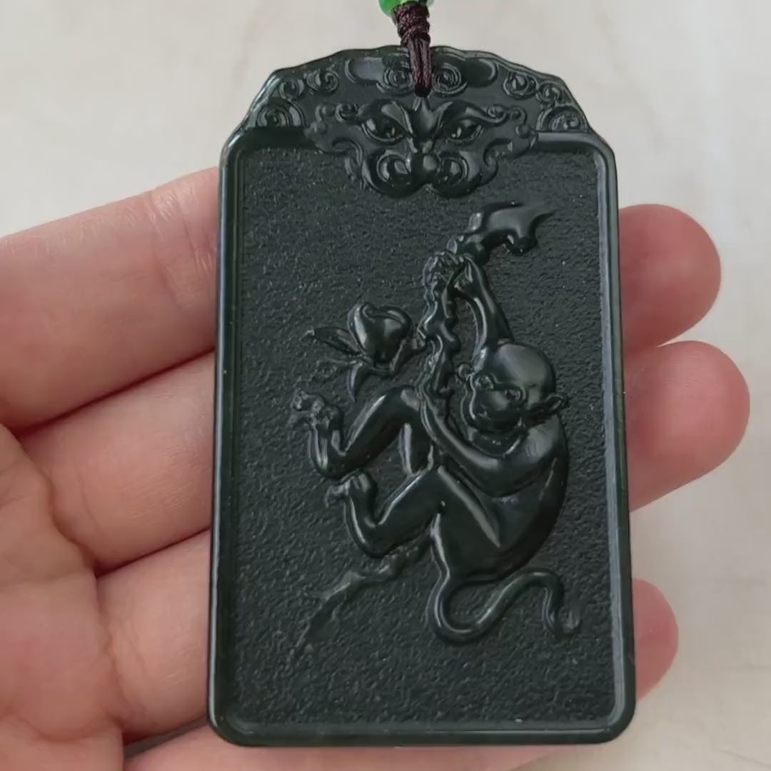 Video of a hand-carved jade pendant in green, depicting a Buddha in lotus meditation with a carved monkey reverse