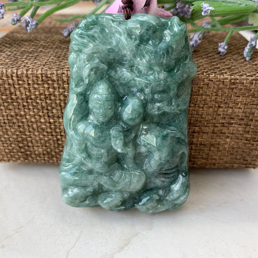 Close-up of green jadeite dragon pendant, front view, polished translucent carved stone with textured relief