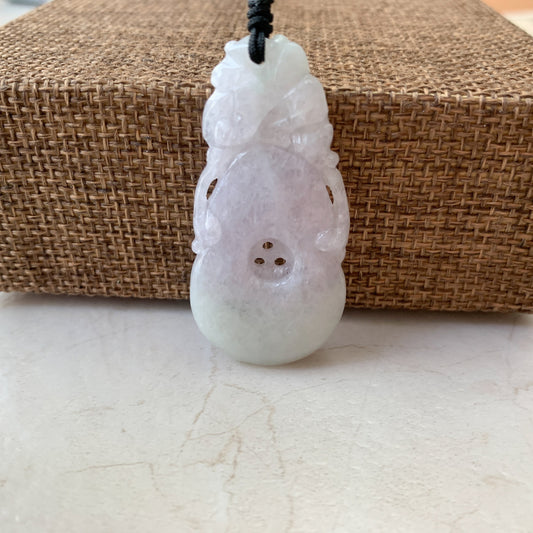 Close-up of rustic light purple jadeite jade peach carved pendant necklace with glossy polished finish on black cord