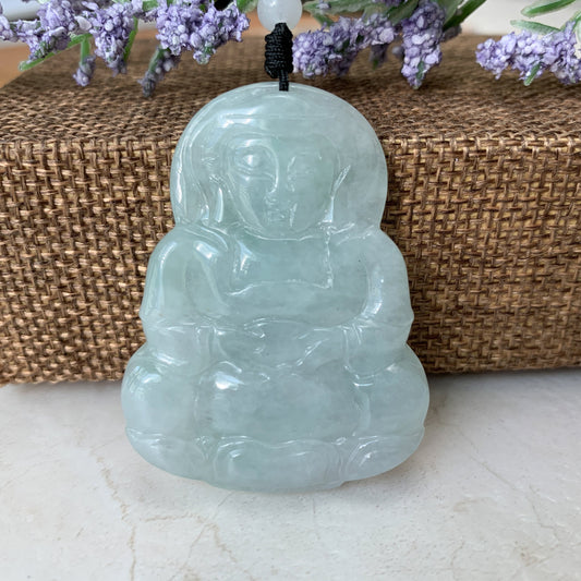 Front view of translucent pale green jade Guan Yin pendant with smooth polished hand-carved details and black cord