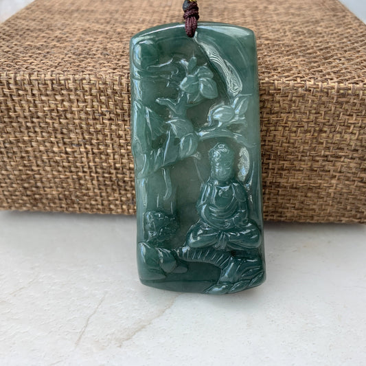 Close-up of green jade carved Buddha pendant necklace, glossy polished finish, front view on woven mat background