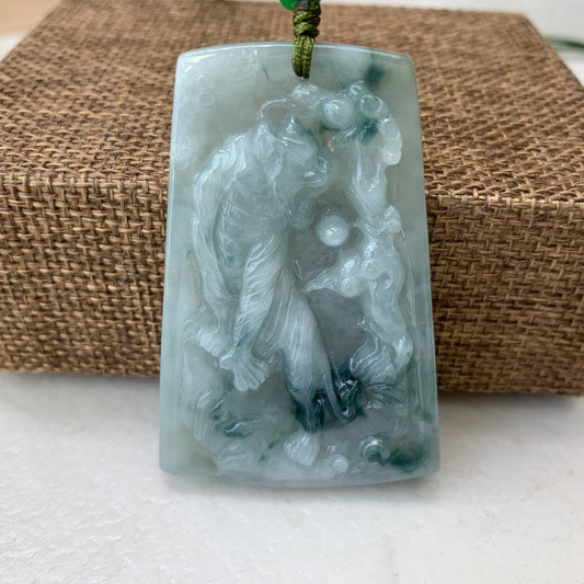 Front view of pale green jadeite tiger carved pendant necklace with glossy translucent finish and woven cord