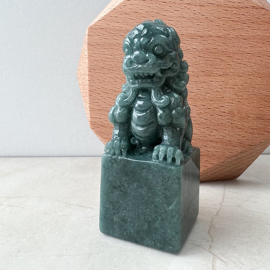 Front view of green jadeite guardian lion sculpture on square base, glossy hand-carved finish, tabletop display